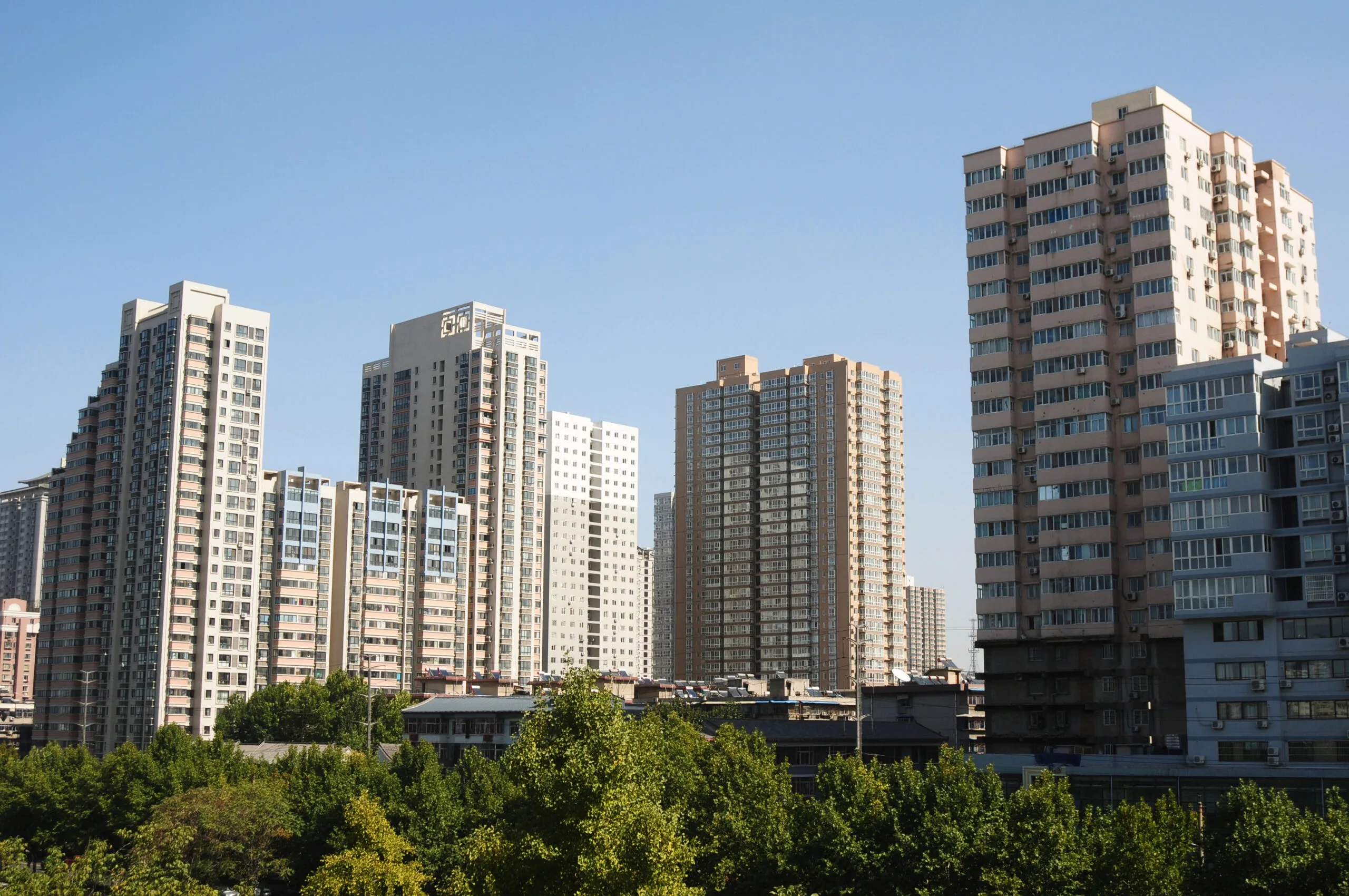 a group of tall buildings with trees in the background