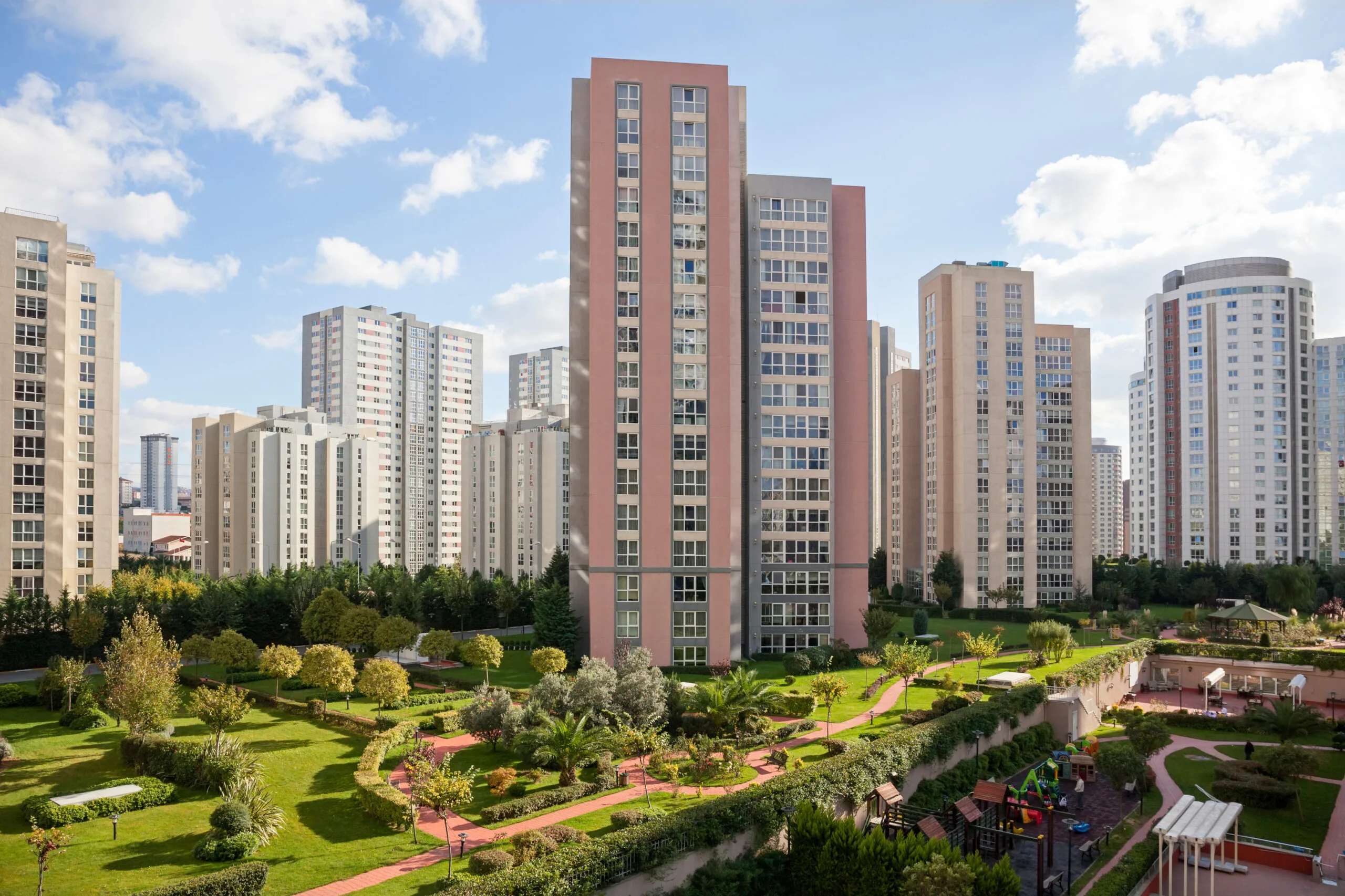 a group of tall buildings with trees and grass